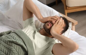 Sleepless man lying in bed at home